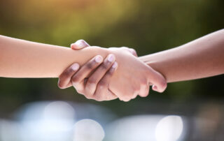 Two people holding hands outside