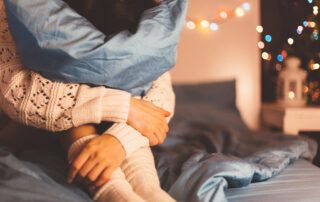 Woman with her head in the pillow while home for the holidays